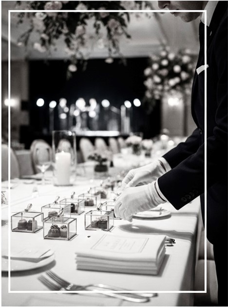 Waiter setting favors at a formal event - Vox Concierge